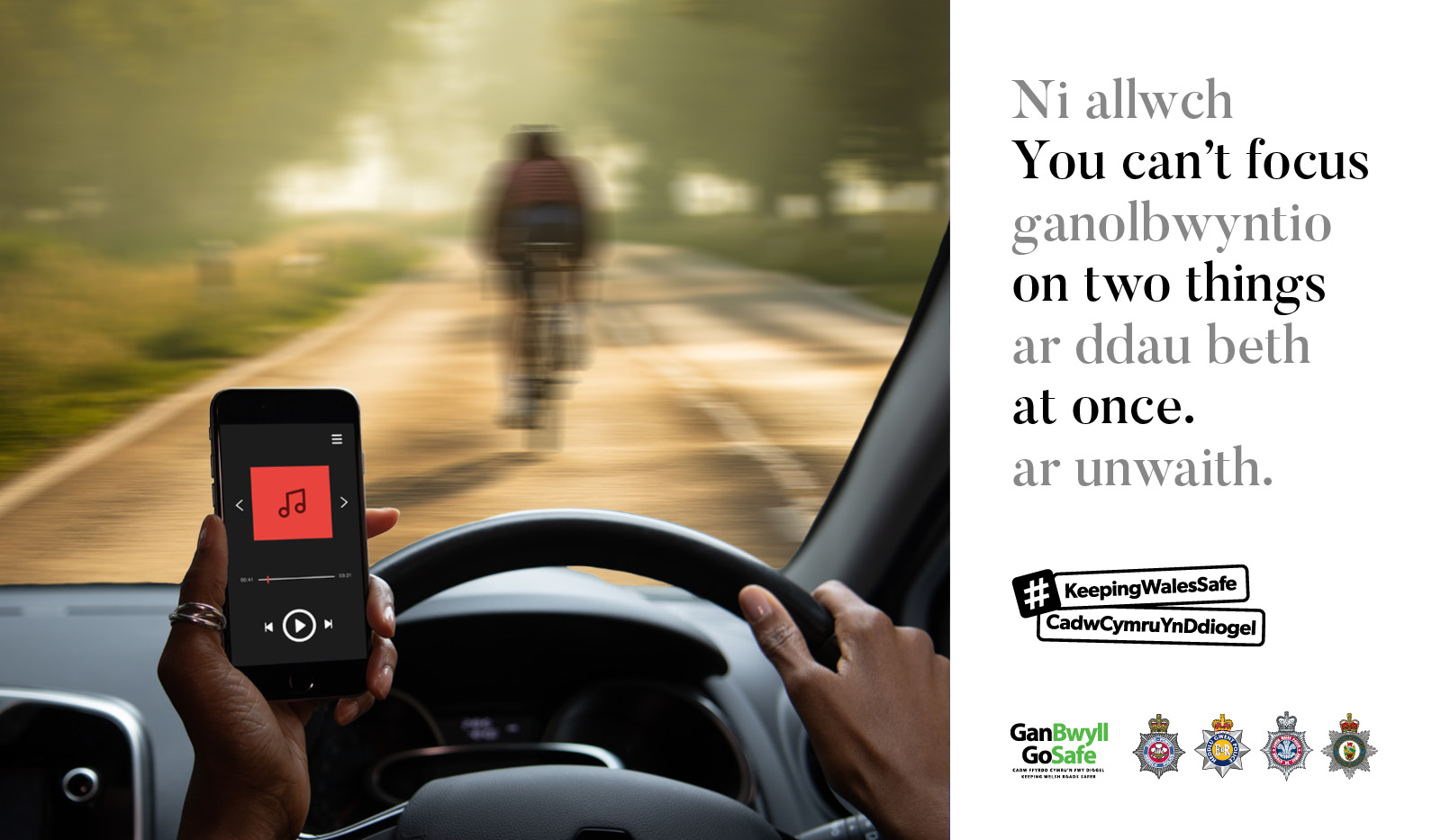 A driver looking at their mobile phone with a cyclist in the road ahead