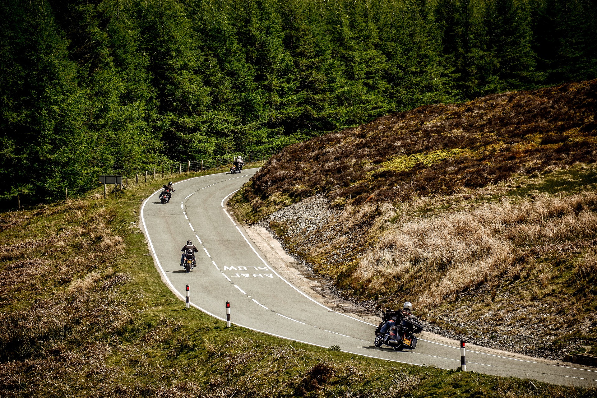Photo of four motorcycles in convoy on a winding, rural road