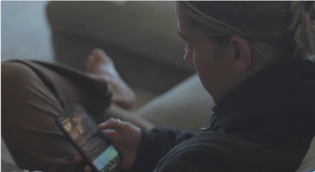 Dark photo of a teenage girl looking at her phone