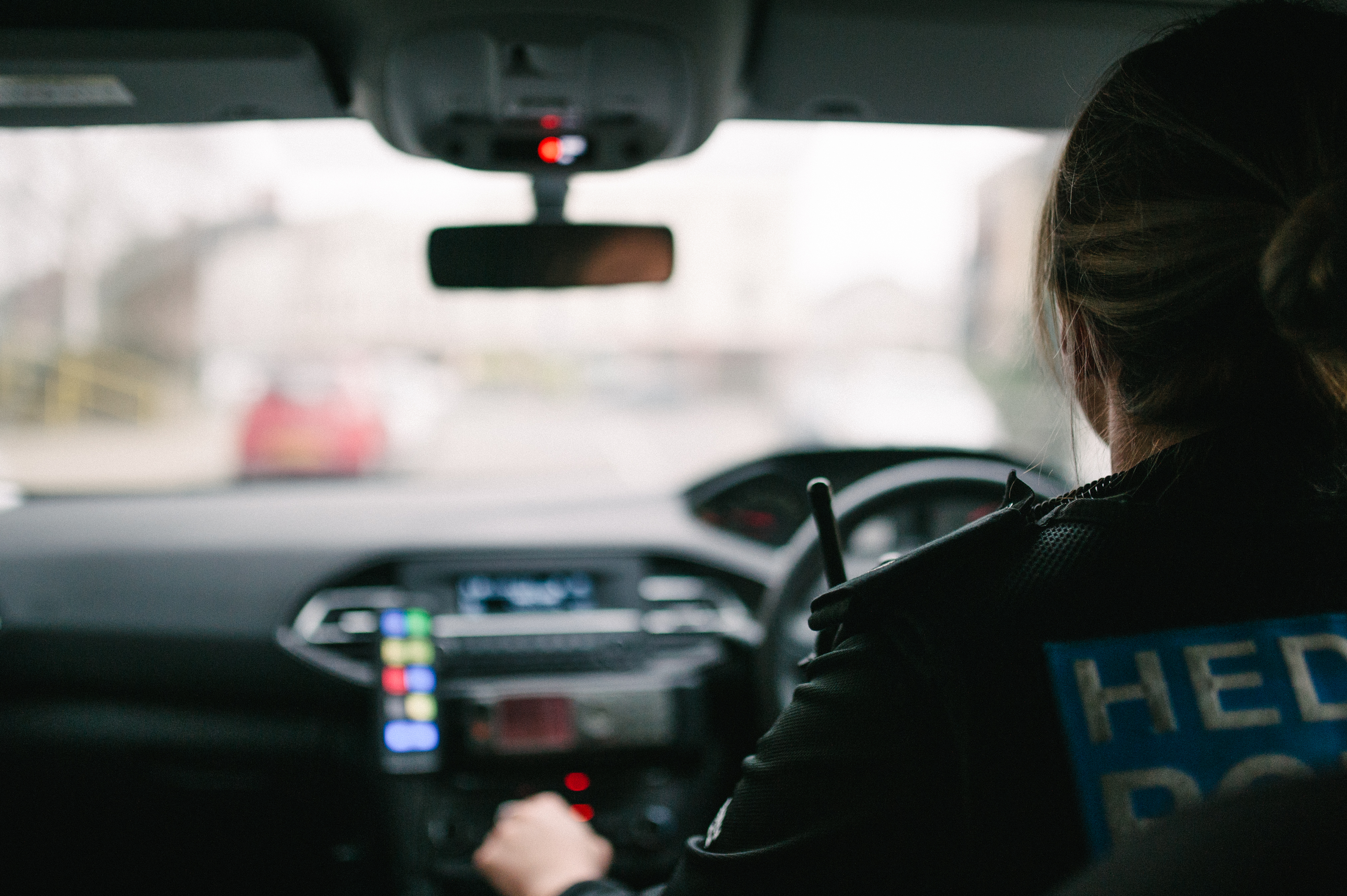 Back of female officer driving a car