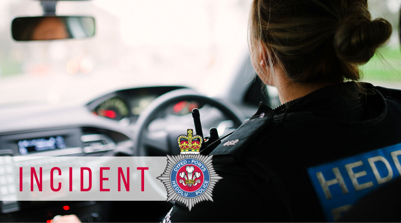 Inside of a police car with the word INCIDENT on a white banner