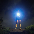 Female runner with light shining on her chest