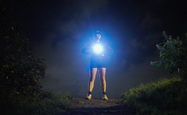 Female runner with light shining on her chest